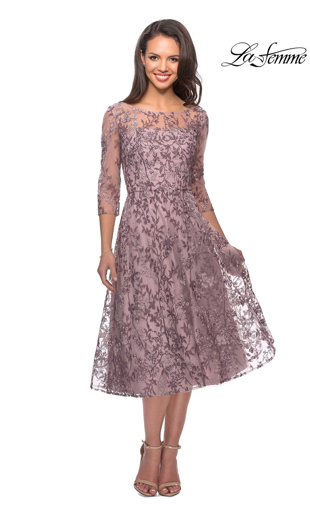Woman in a mauve, floral beaded lace Midi Mother of Bride Dress: La Femme 27971 with three-quarter sleeves and embroidery, standing and smiling.